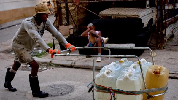 Homem carrega galões de água em rua de Havana. Cuba, 27 de agosto de 2026 - Sputnik Brasil
