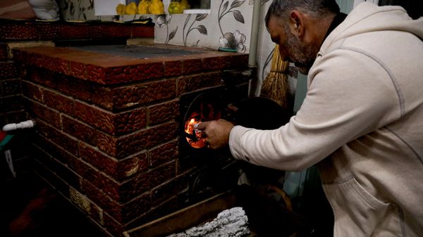 Morador alimenta um fogão a lenha que aquece sua casa em meio à crise energética na Europa, em Chisinau. Moldávia, 16 de outubro de 2022 - Sputnik Brasil