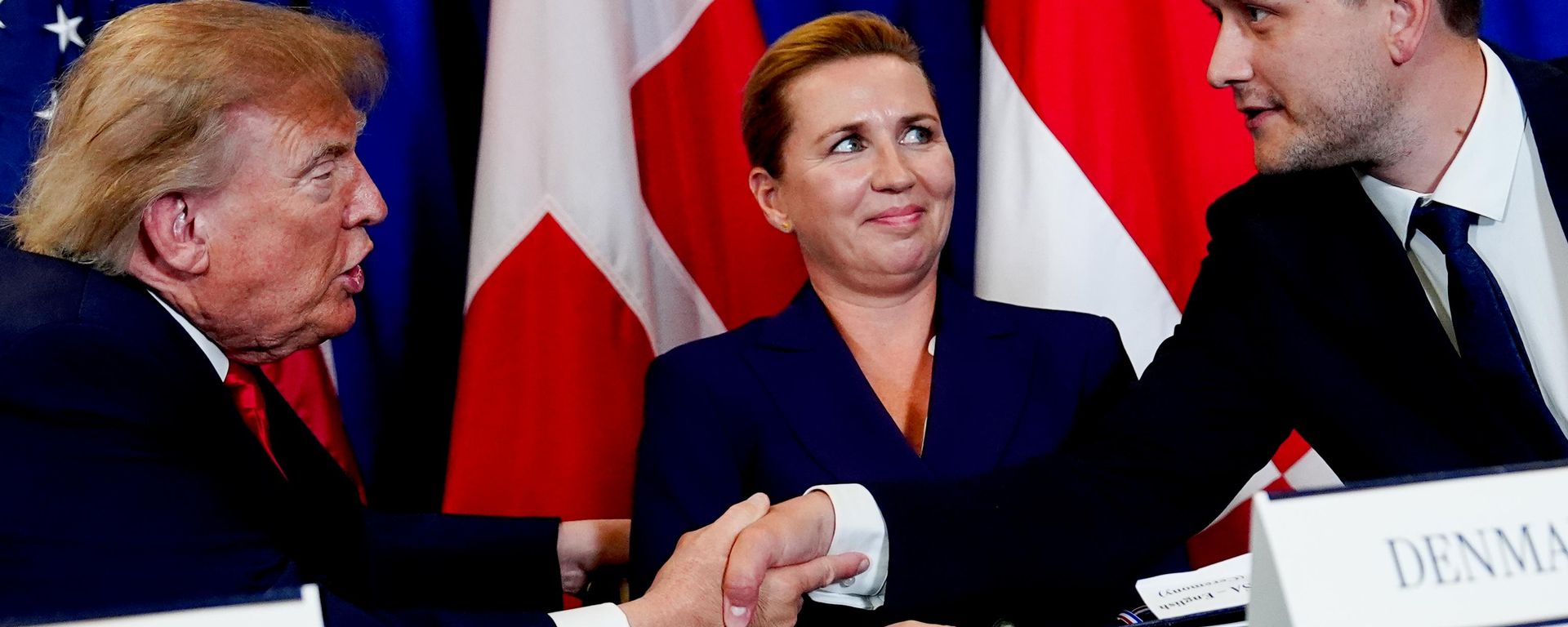 O presidente norte-americano Donald Trump (E) aperta a mão do primeiro-ministro da Groenlândia, Jens-Frederik Nielsen (D), enquanto a primeira-ministra da Dinamarca, Mette Frederiksen (C), observa durante a cerimônia de assinatura do acordo de segurança na Assembleia Geral das Nações Unidas, na sede da ONU, 22 de setembro de 2026 - Sputnik Brasil, 1920, 24.09.2026