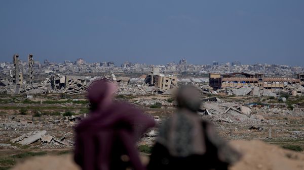 Mulheres palestinas observam uma área fortemente danificada após a guerra entre Israel e o Hamas em Nuseirat, no centro da Faixa de Gaza, em 7 de outubro de 2026 - Sputnik Brasil