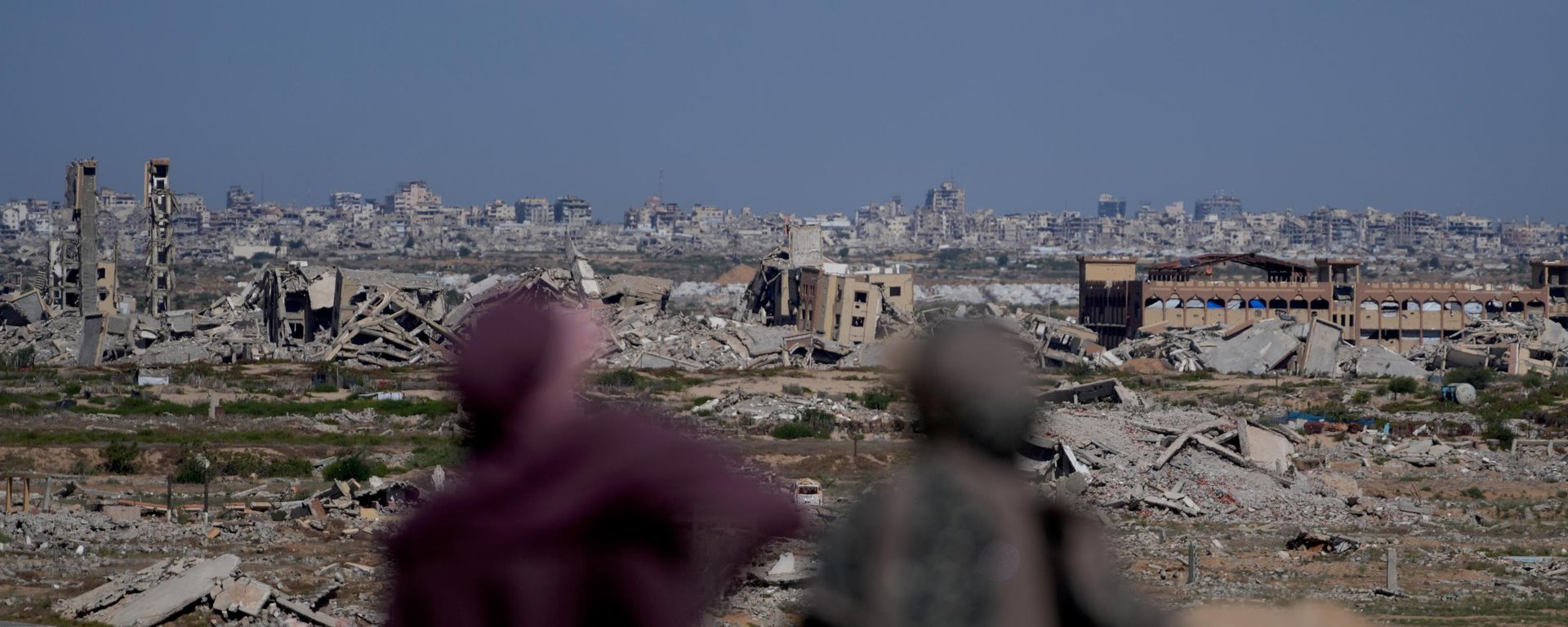 Mulheres palestinas observam uma área fortemente danificada após a guerra entre Israel e o Hamas em Nuseirat, no centro da Faixa de Gaza, em 7 de outubro de 2026 - Sputnik Brasil, 1920, 07.10.2026
