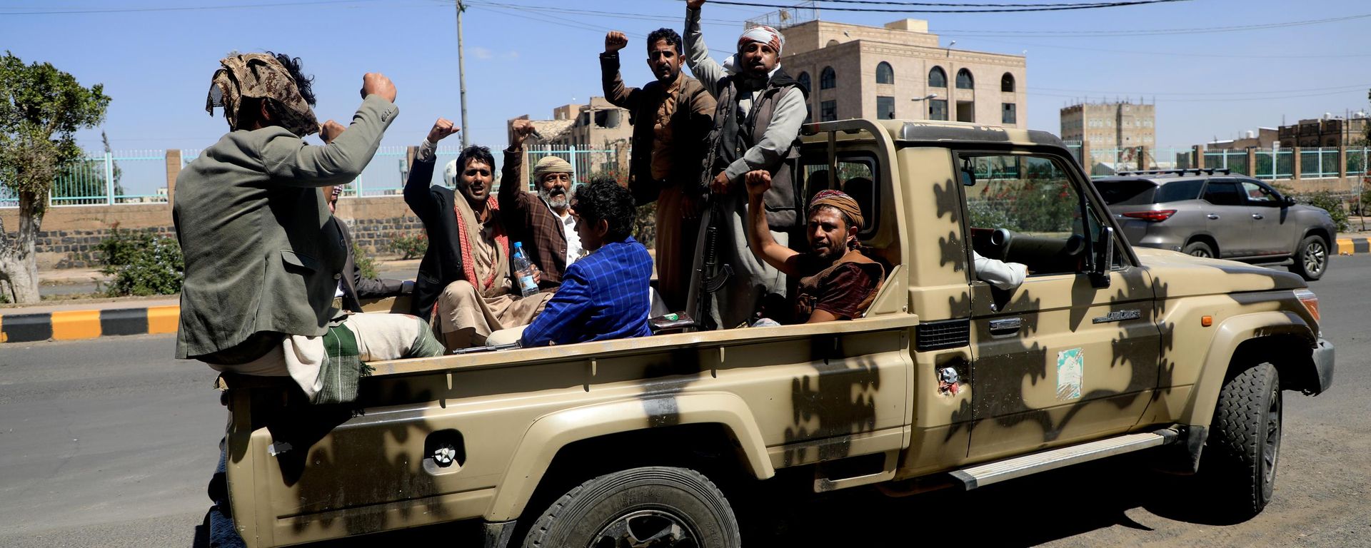 Apoiadores dos houthis entoam slogans enquanto viajam na carroceria de uma caminhonete durante um comício em Sanaa. Iêmen, 7 de outubro de 2026 - Sputnik Brasil, 1920, 11.10.2026
