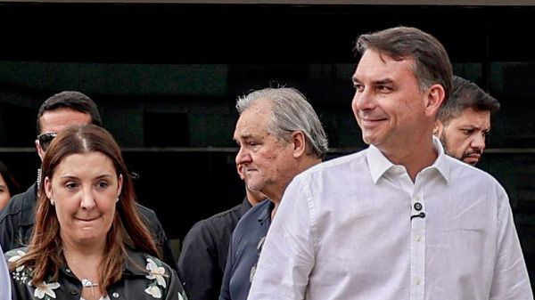 O candidato e senador, Flávio Bolsonaro fala com jornalistas ao seu lado esquerdo, Daniela Marques, após missa na Catedral Metropolitana de Brasília, em 12 de outubro de 2026 - Sputnik Brasil
