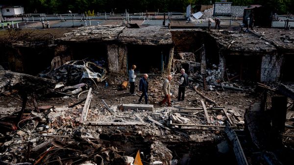 Ucranianos andam em meio a destroços na região metropolitana de Kiev, em 30 de setembro de 2026 - Sputnik Brasil
