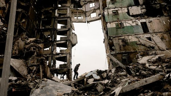 Um morador procura pertences nas ruínas de um prédio de apartamentos destruído durante os combates - Sputnik Brasil