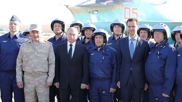 Presidente russo Vladimir Putin, ministro da Defesa russo Sergei Shoigu (E), presidente sírio Bashar Assad (D) e militares russos durante a visita de Putin à base aérea síria de Hmeymim - Sputnik Brasil