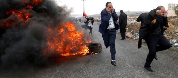 Advogados palestinos fogem durante confrontos com as tropas israelenses durante os protestos contra a decisão de Donald Trump de reconhecer Jerusalém como capital do Estado judeu, em 13 de dezembro de 2017 - Sputnik Brasil