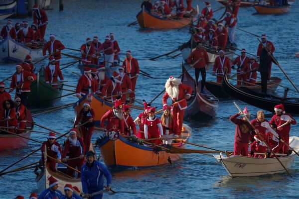 Pessoas vestidas de Papais Noéis durante a regata natalina em Veneza, na Itália, em 17 de dezembro de 2017 - Sputnik Brasil