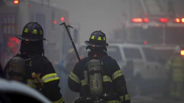New York City Fire Department firefighters walk towards the site of a residential apartment building collapse and fire in New York City's East Village neighborhood - Sputnik Brasil