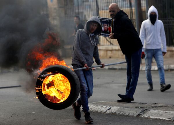 Palestino com pneu em chamas durante confrontos com militares israelenses em Belém - Sputnik Brasil