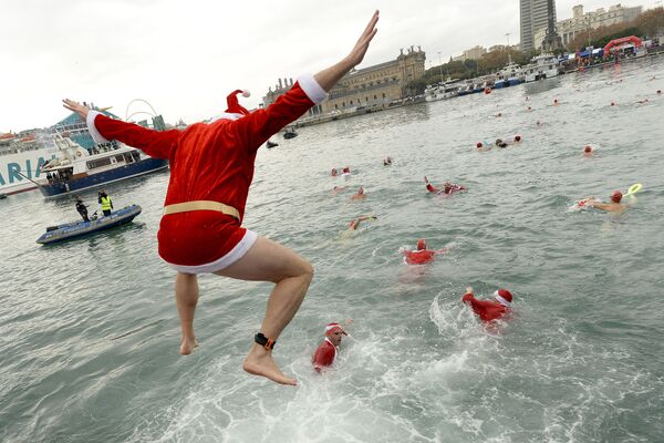 Pessoas vestidas de Papai Noel participam da natação de Natal em Barcelona, Espanha - Sputnik Brasil