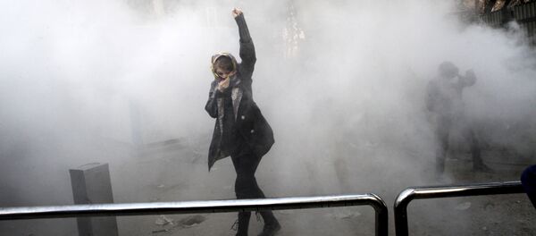 طالبة جامعية في مظاهرة داخل جامعة طهران وقت إلقاء قنبلة دخان من قبل الشرطة الإيرانية لمكافحة الشغب - Sputnik Brasil