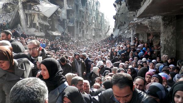 Refugiados Palestinos do campo de Yarmouk, próximo a Damasco, na Síria, enquanto se organizam para retirar alimentos - Sputnik Brasil