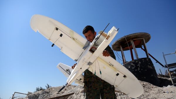 Membro das Forças Democráticas da Síria inspeciona drone derrubado alegadamente pertencente ao grupo terrorista Daesh (foto de arquivo) - Sputnik Brasil
