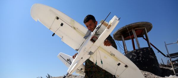 Membro das Forças Democráticas da Síria inspeciona drone derrubado alegadamente pertencente ao grupo terrorista Daesh (foto de arquivo) - Sputnik Brasil