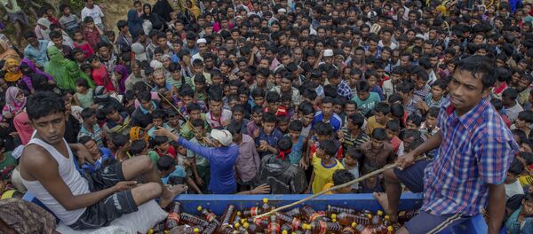Rohingya Muslims, who crossed over from Myanmar into Bangladesh, wait during distribution of food items near Kutupalong refugee camp, Bangladesh, Tuesday, Sept. 19, 2017. - Sputnik Brasil
