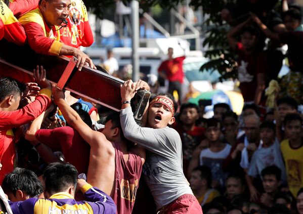 Menino segura cruz com Cristo Negro durante processão anual religiosa em Manila, Filipinas - Sputnik Brasil