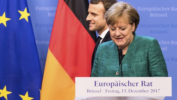 Presidente francês, Emmanuel Macron, à esquerda, passa por detrás da Chanceler alemã, Angela Merkel, que se prepara para falar durante conferência de imprensa no encontro da União Europeia, em Bruxelas, na sexta-feira, 15 de dezembro, de 2017. - Sputnik Brasil