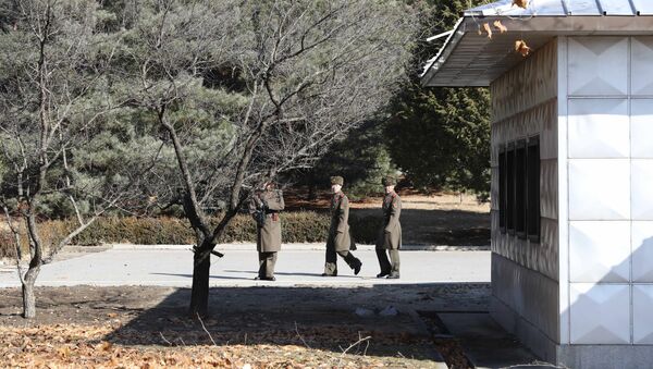 Three North Korean soldiers look at the South side at the spot where a North Korean soldier crossed the border at the Panmunjom in the Demilitarized Zone, South Korea - Sputnik Brasil