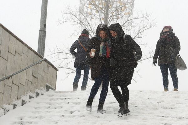 Moças descem as escadas do metrô durante nevada, Moscou - Sputnik Brasil