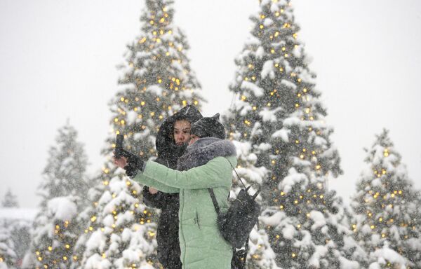 Moças posam para foto durante nevada na Praça do Manege, no centro de Moscou - Sputnik Brasil