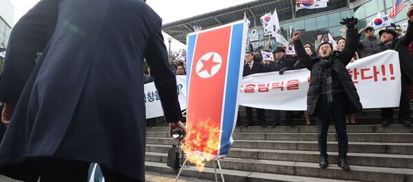 A member of a South Korean conservative civic group burns a North Korean national flag during a protest opposing North Korea's participation in the 2018 Pyeongchang Winter Olympics, in Seoul, South Korea, January 22, 2018 - Sputnik Brasil