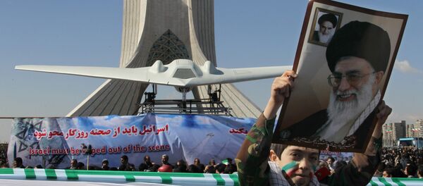 Menino mostra um cartaz do líder supremo do Irã, aiatolá Ali khamenei, enquanto passa perto do drone estadunidense RQ-170 Sentinel - Sputnik Brasil