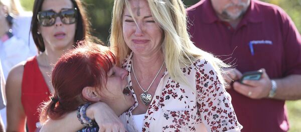Mulheres choram após tiroteio em escola na Flórida. - Sputnik Brasil