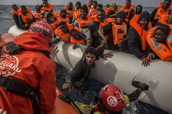 Membros da organização Proactiva Open Arms salvam imigrantes que saíram da Líbia para alcançar o solo europeu - Sputnik Brasil