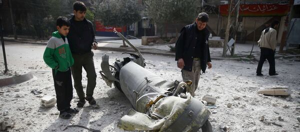 Transeuntes observam restos de mísseis na cidade sitiada de Douma, no leste de Ghouta, em Damasco, Síria, 23 de fevereiro de 2018 Transeuntes observam restos de mísseis na cidade sitiada de Douma, no leste de Ghouta, em Damasco, Síria, 23 de fevereiro de 2018 - Sputnik Brasil