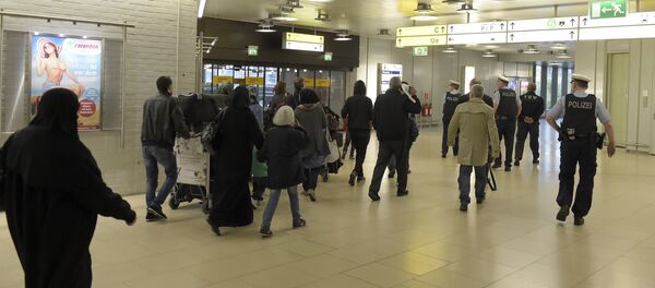 Policiais escoltam um grupo de refugiados após a chegada ao aeroporto de Hanôver, no centro da Alemanha, em 4 de abril de 2016. Policiais escoltam um grupo de refugiados após a chegada ao aeroporto de Hanôver, no centro da Alemanha, em 4 de abril de 2016. - Sputnik Brasil