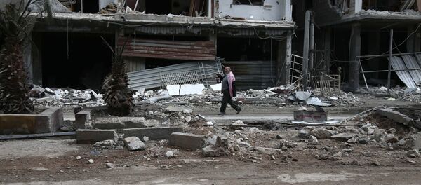 Civil caminha por rua destruída de Haza, na região síria de Ghouta Oriental, perto de Damasco - Sputnik Brasil
