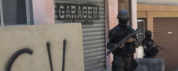 Militar na Rocinha ao lado de muro com as inscrições do Comando Vermelho. Militar na Rocinha ao lado de muro com as inscrições do Comando Vermelho. - Sputnik Brasil
