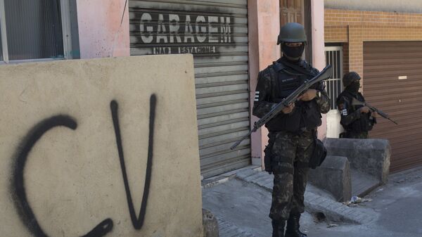 Militar na Rocinha ao lado de muro com as inscrições do Comando Vermelho. - Sputnik Brasil