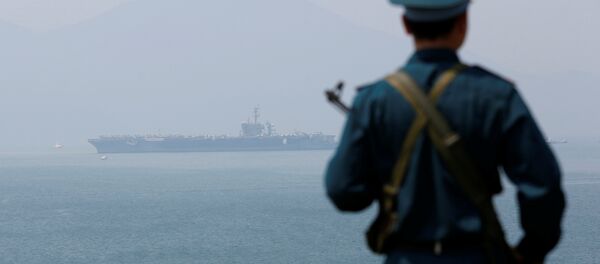Soldado vietnamita e o porta-aviões USS Carl Vinson ao fundo. Foto de março de 2018. - Sputnik Brasil