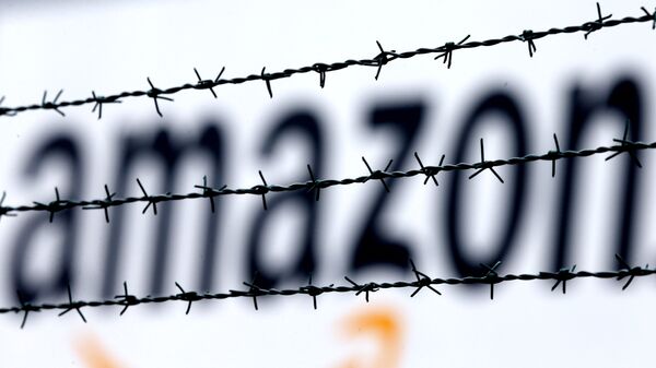 Logotipo da Amazon é visto atrás de cerca, em centro logístico da empresa em Rheinberg, na Alemanha, em 19 de fevereiro de 2013 (foto de arquivo) - Sputnik Brasil