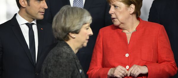 Primeira ministra britânica, Theresa May (centro), passa em frente da chanceler alemã, Angela Merkel (direita), e de Emmanuel Macron (esquerda), presidente da França. - Sputnik Brasil
