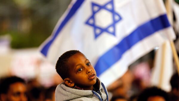 Um menino participa do protesto em Tel Aviv, Israel, contra o plano do governo de deportar imigrantes africanos. - Sputnik Brasil