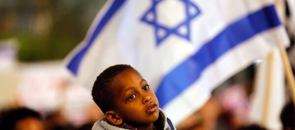Um menino participa do protesto em Tel Aviv, Israel, contra o plano do governo de deportar imigrantes africanos. - Sputnik Brasil