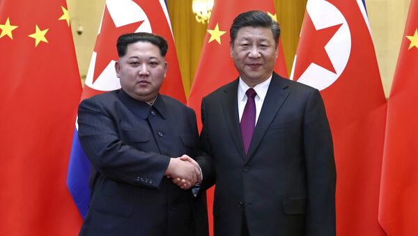 Nesta foto fornecida no dia 28 de março de 2018, pela Agência de Notícias Xinhua da China, está o líder norte-coreano Kim Jong-un, à esquerda, e o presidente chinês Xi Jinping apertando as mãos em Pequim, na China. - Sputnik Brasil