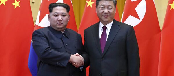 Nesta foto fornecida no dia 28 de março de 2018, pela Agência de Notícias Xinhua da China, está o líder norte-coreano Kim Jong-un, à esquerda, e o presidente chinês Xi Jinping apertando as mãos em Pequim, na China. - Sputnik Brasil