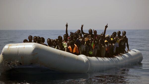 Migrantes e refugiados resgatados pela ONG Proactiva Open Arms da Espanha, depois à deriva em um bote de borracha no Mar Mediterrâneo, a cerca de 29 quilômetros ao norte de Sabratha, Líbia. - Sputnik Brasil