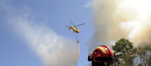 Bombeiros observam helicóptero Kamov jogando água sobre incêndio florestal em Penoita, perto de Vouzela, centro de Portugal, 23 de agosto de 2013 - Sputnik Brasil