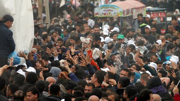 Os palestinos recebem comida durante um protesto na cidade de barracas ao longo da fronteira de Israel com Gaza, exigindo o direito de retornar à sua terra natal, a leste da cidade de Gaza - Sputnik Brasil