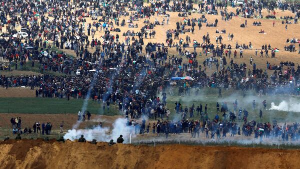 Militares israelenses usam gás lacrimogêneo contra os manifestantes palestinos na Faixa de Gaza, em 30 de março de 2018 - Sputnik Brasil