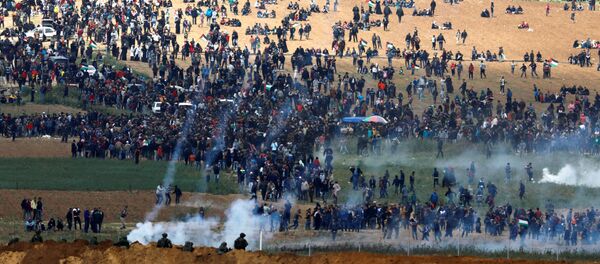 Militares israelenses usam gás lacrimogêneo contra os manifestantes palestinos na Faixa de Gaza, em 30 de março de 2018 - Sputnik Brasil