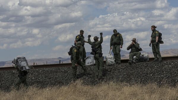 Agentes de patrulhamento fronteiriço norte-americanos com fardos de maconha na fronteira entre México e EUA - Sputnik Brasil