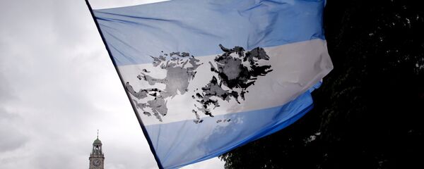 Homem segurando bandeira argentina com imagem das ilhas Malvinas - Sputnik Brasil