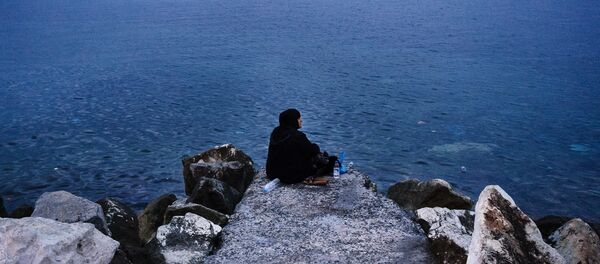 Mulher idosa sentada no quebra-mar do porto de Mytilene, Grécia - Sputnik Brasil