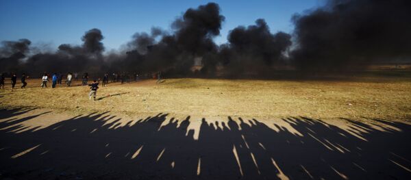 Manifestantes palestinos durante os confrontos com soldados israelenses na fronteira entre a Faixa de Gaza e Israel - Sputnik Brasil